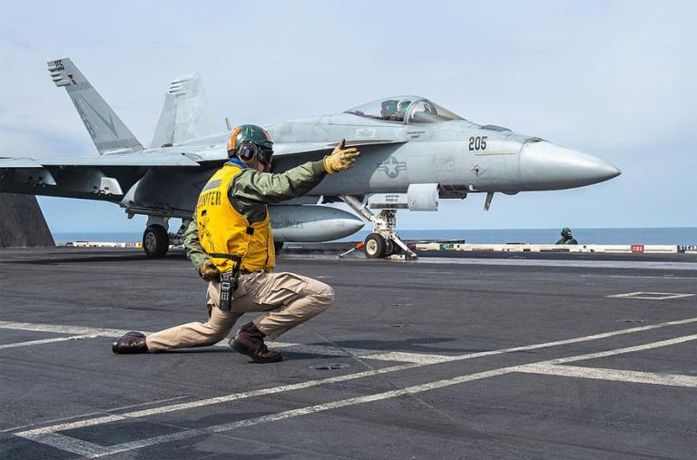 Photo of an F-18 fighter jet launching from a U.S. aircraft carrier.
